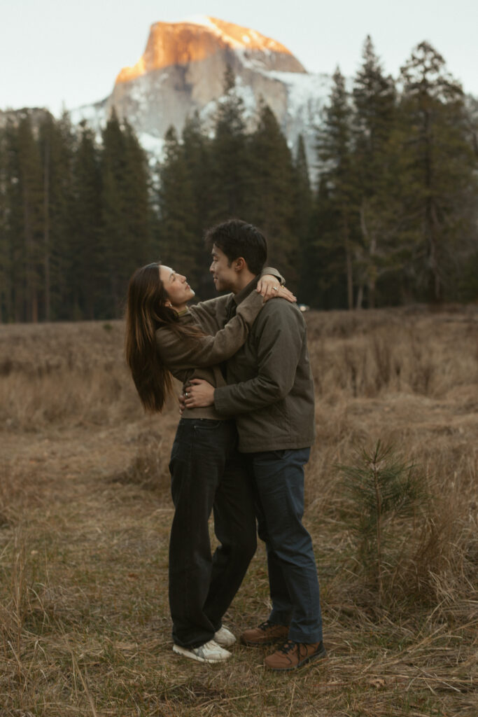 Emotional surprise proposal in Cooks Meadow Yosemite as Johnny kneels and Lydia reacts with laughter and tears.