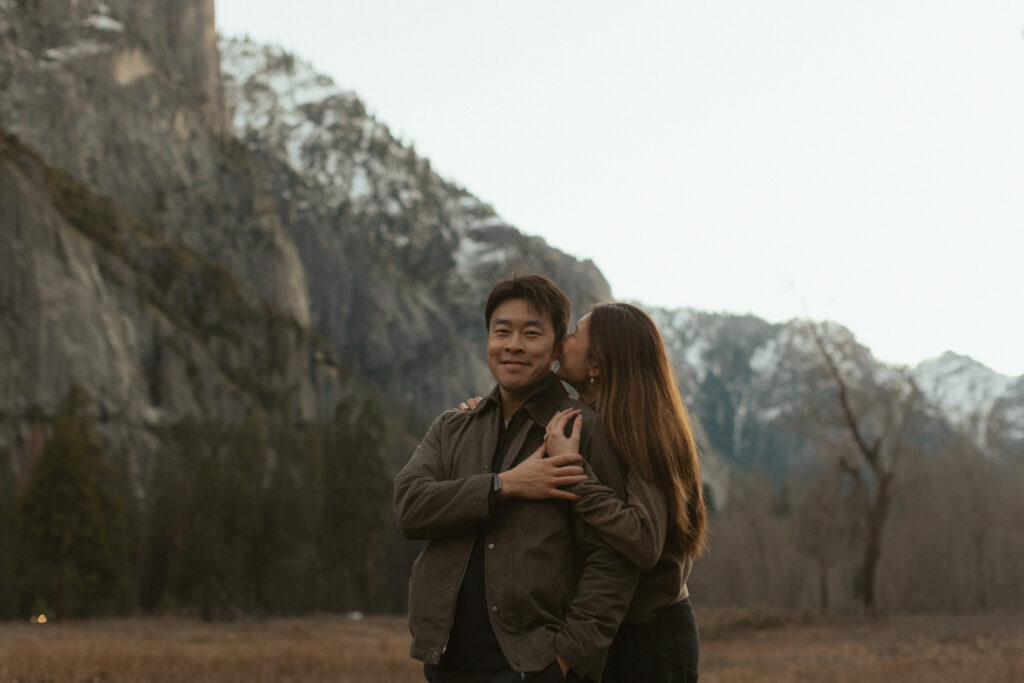 Emotional surprise proposal in Cooks Meadow Yosemite as Johnny kneels and Lydia reacts with laughter and tears.