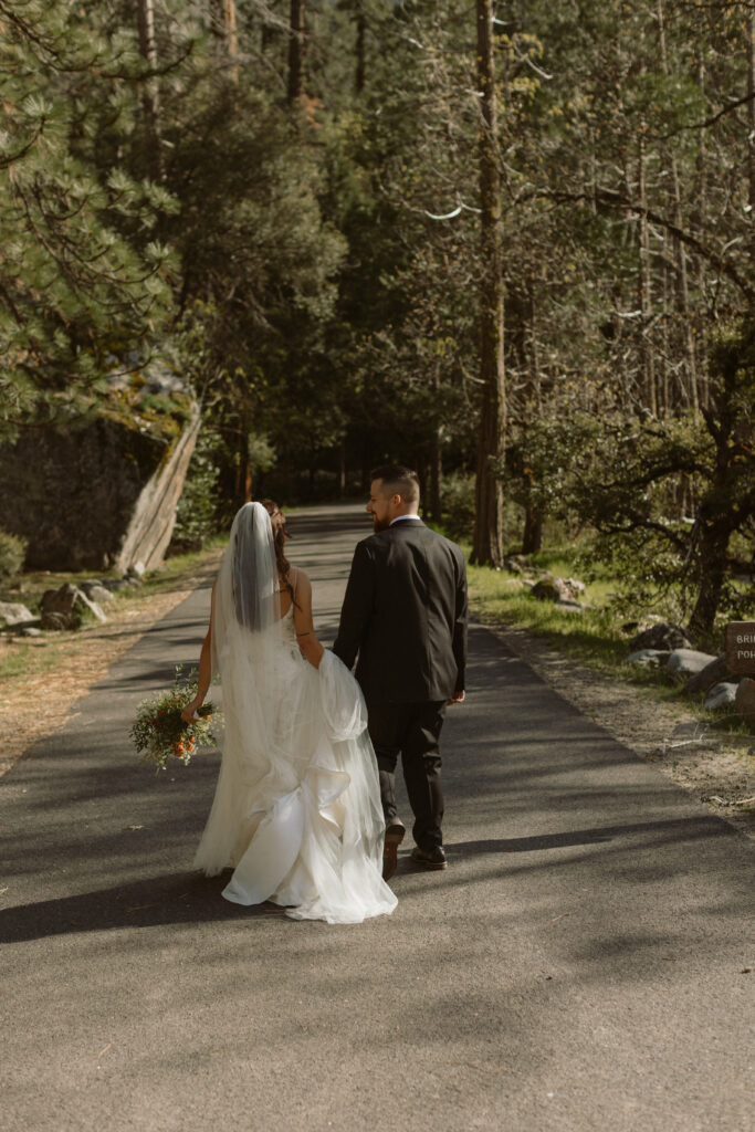 A couple walks through the trees on Their California Elopement Day. W
