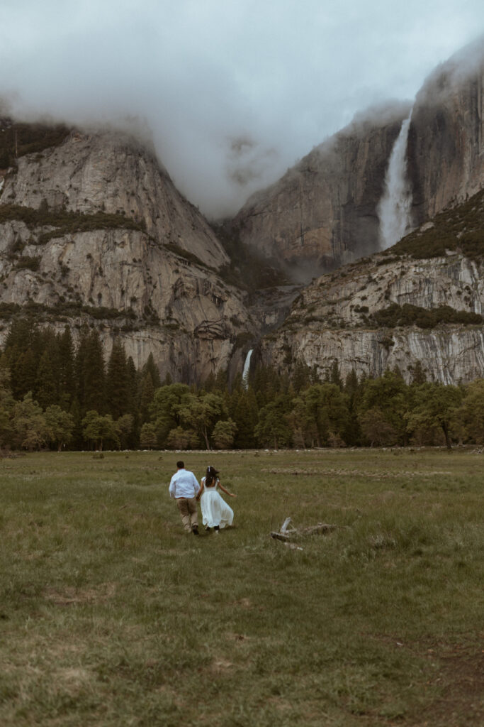 Couple runs throughYosemite Meadow after getting engaged, A Yosemite Park Photographer takes couples candid portraits. 