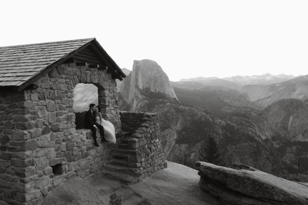 Couple sits in the geology hut at glacier point while a local Yosemite wedding photographer takes their photos 