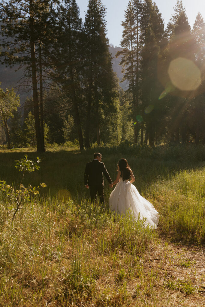 A couple walking through cooks meadow at sunrise in Yosemite valley 