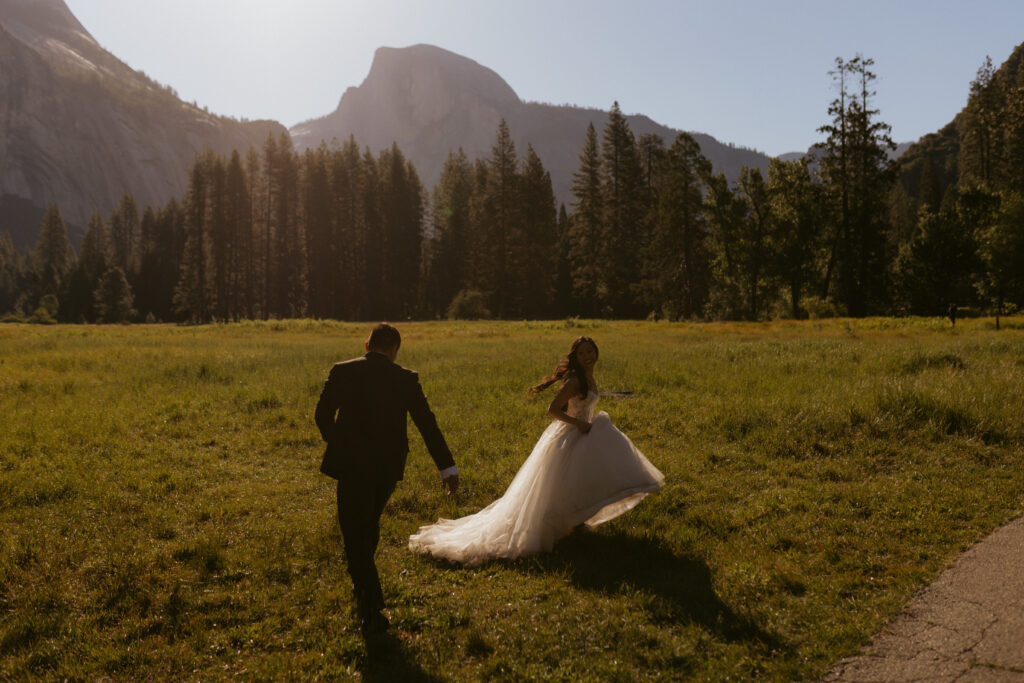 bride and groom Play in the meadow of Yosemite in the early morning at cooks meadow Yosemite 