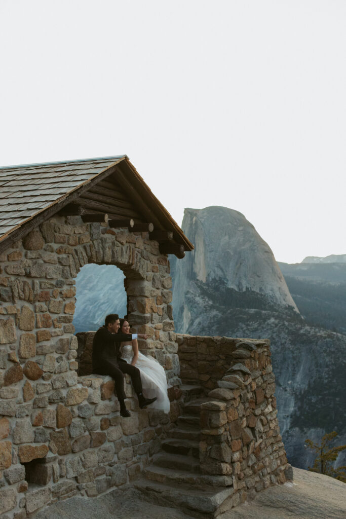 Couple sits in the geology hut at glacier point while a local Yosemite wedding photographer takes their photos 