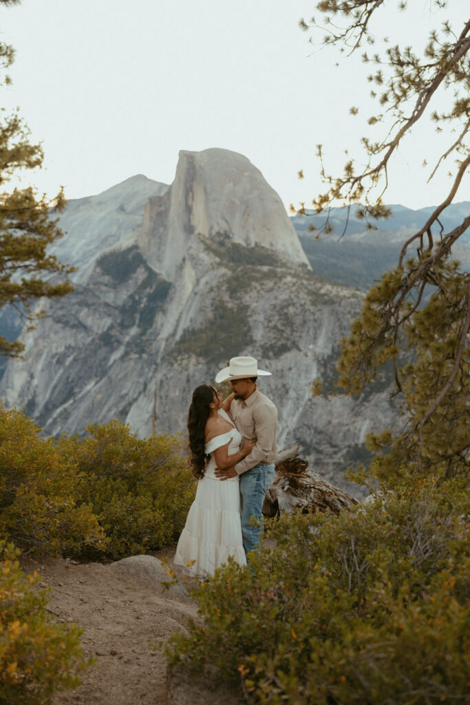 A couple Embraces at Glacier point over looking Half dome in Yosemite 